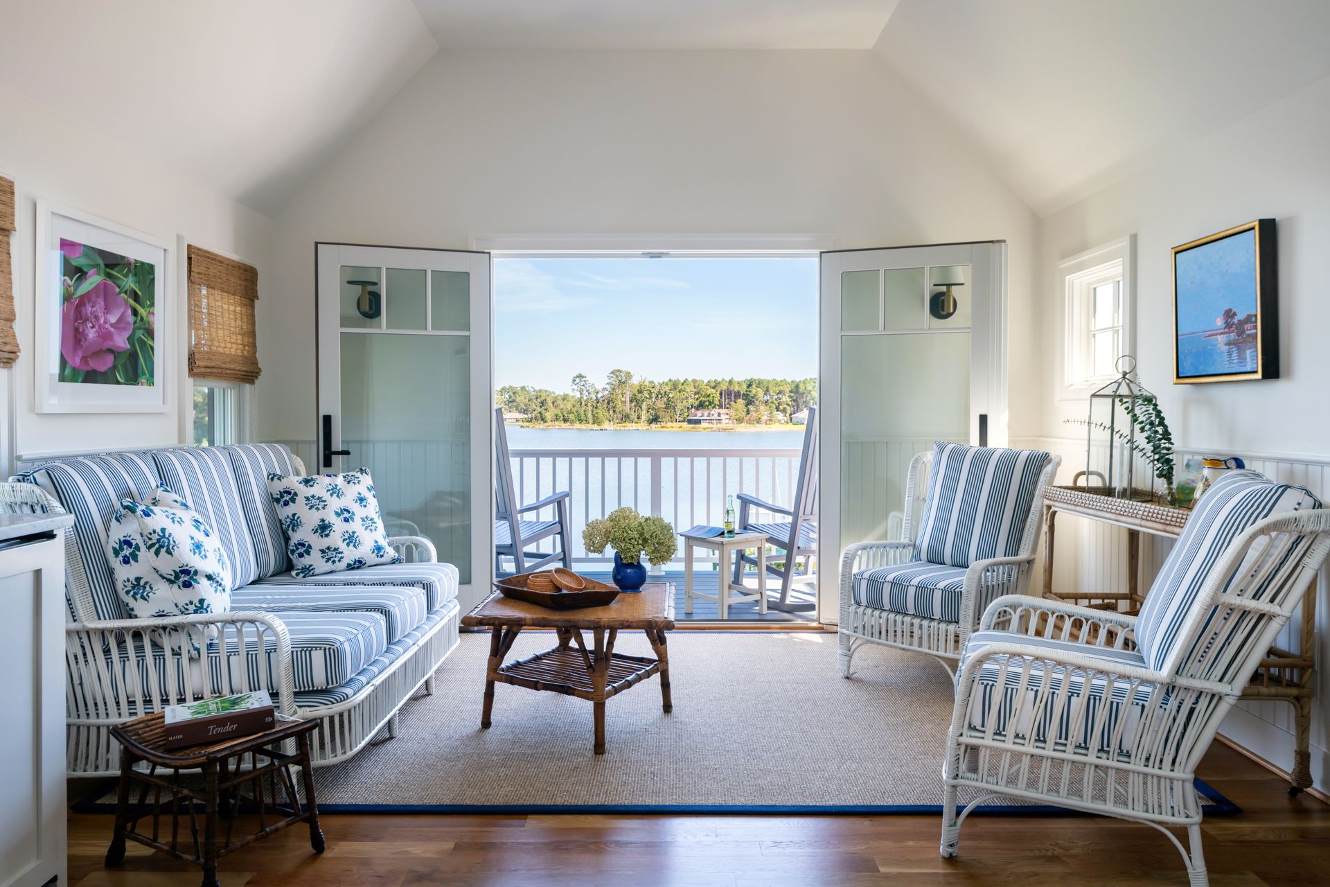 a living room with a couch and chairs with a view of the water