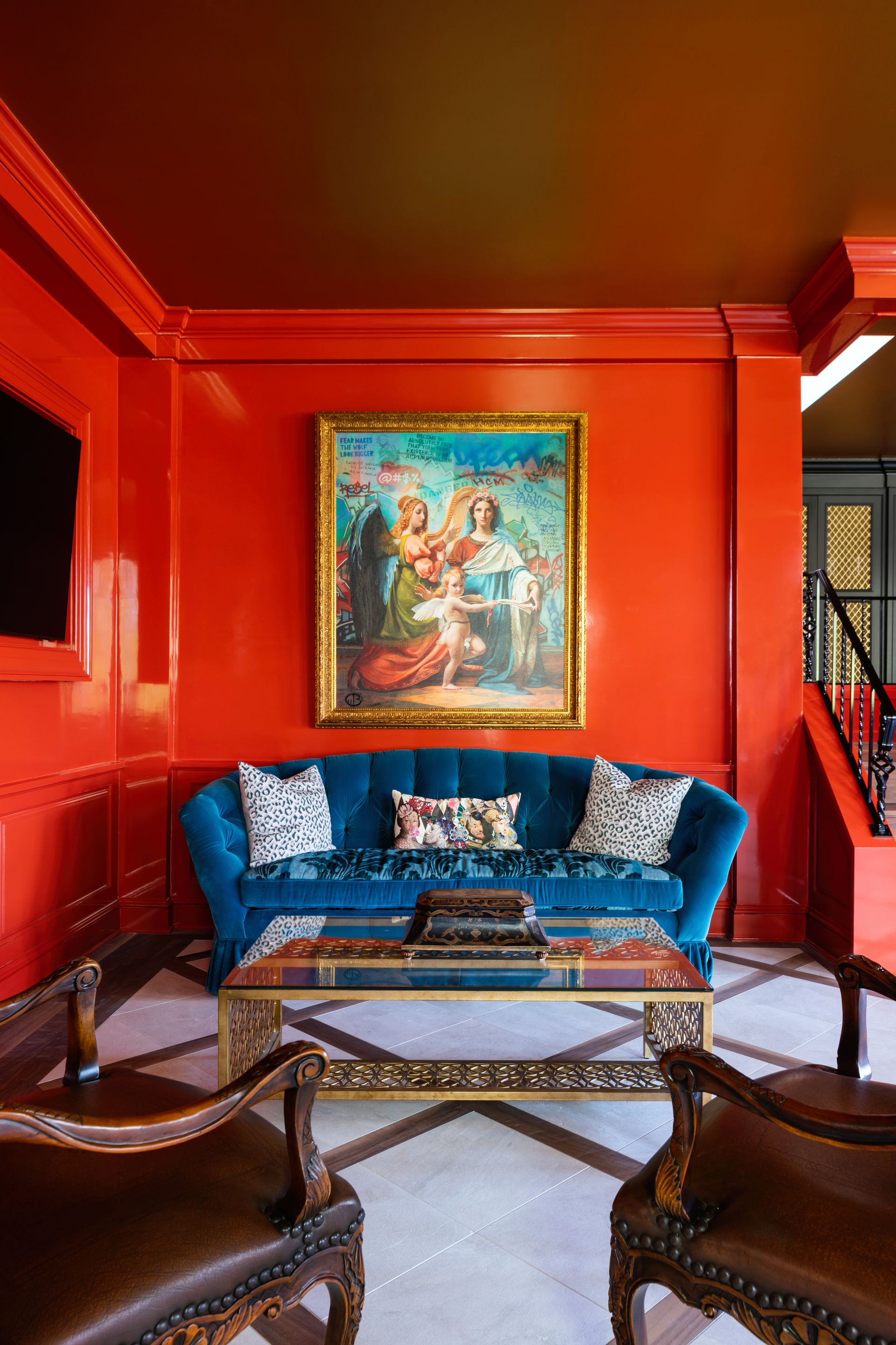 a living room with red walls and a blue couch