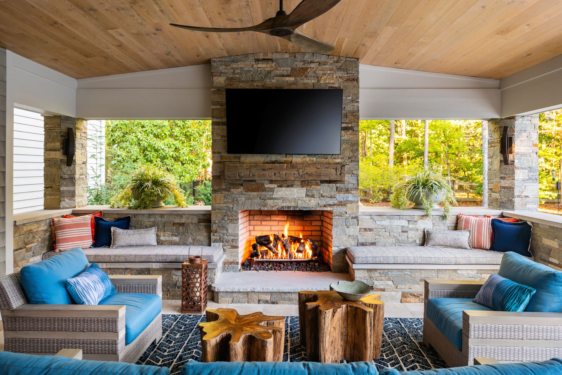 an outdoor living room with a fireplace and a flat screen tv