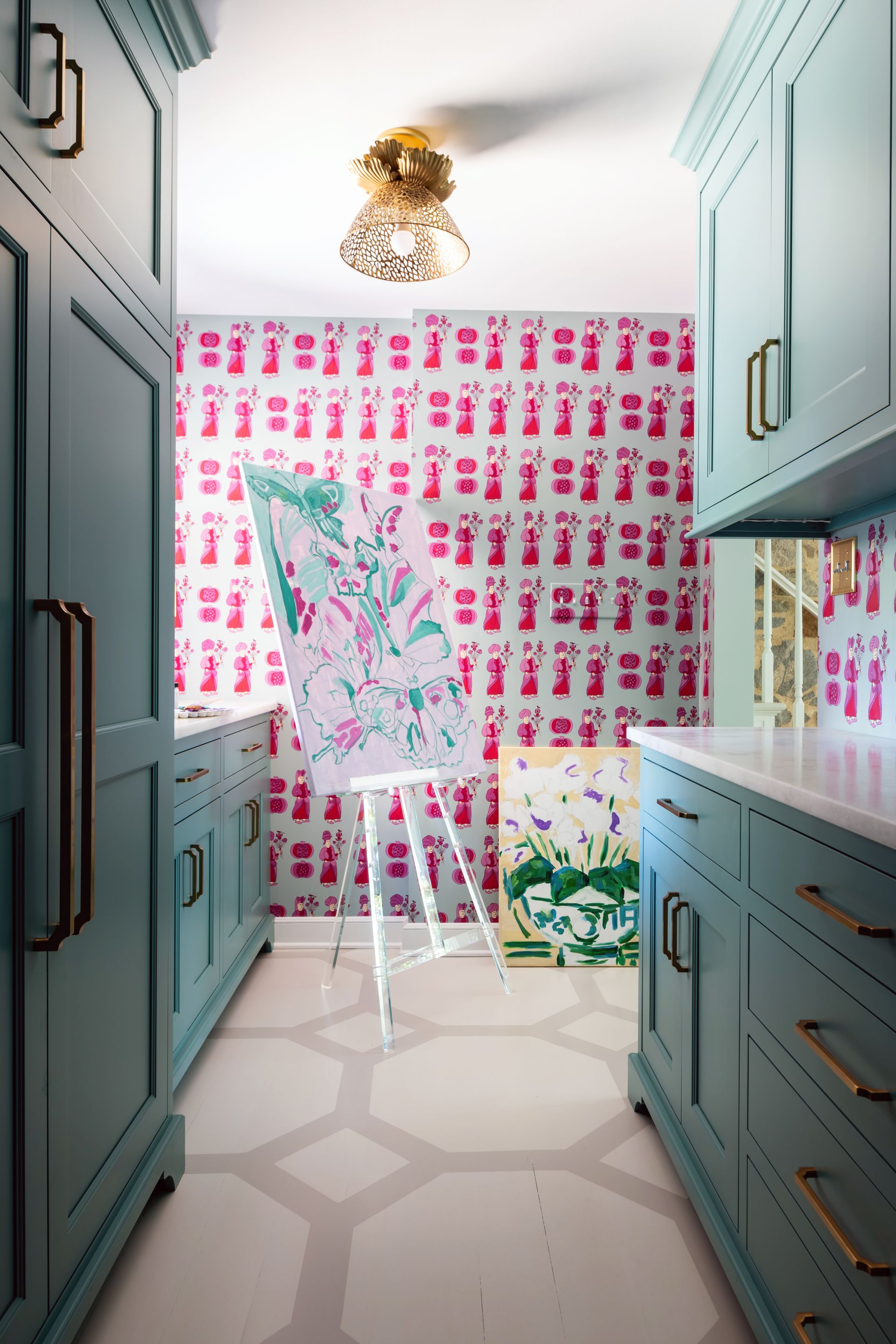 a room with blue cabinets and a painting on the floor