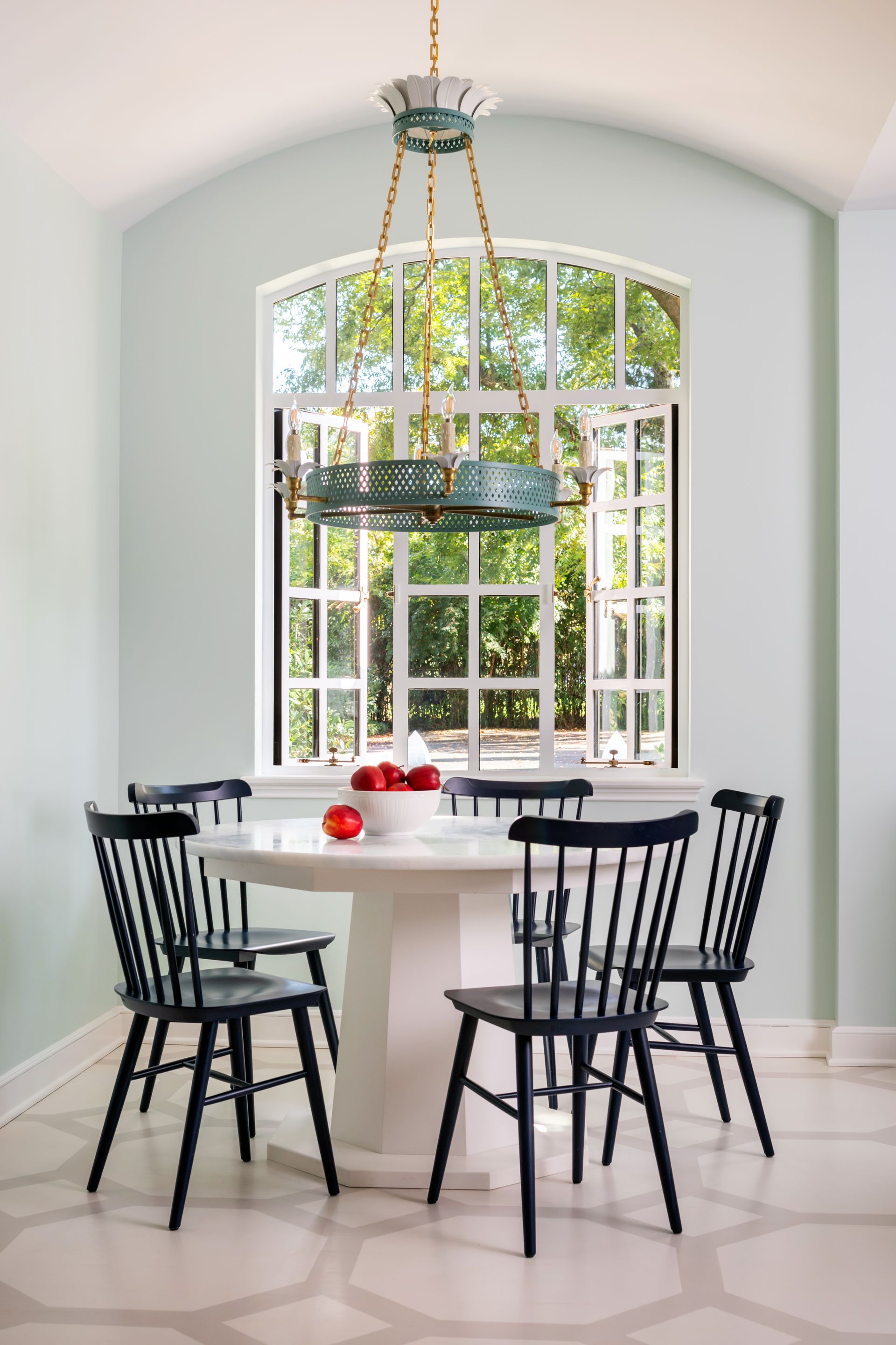 a dining room with a white table and black chairs