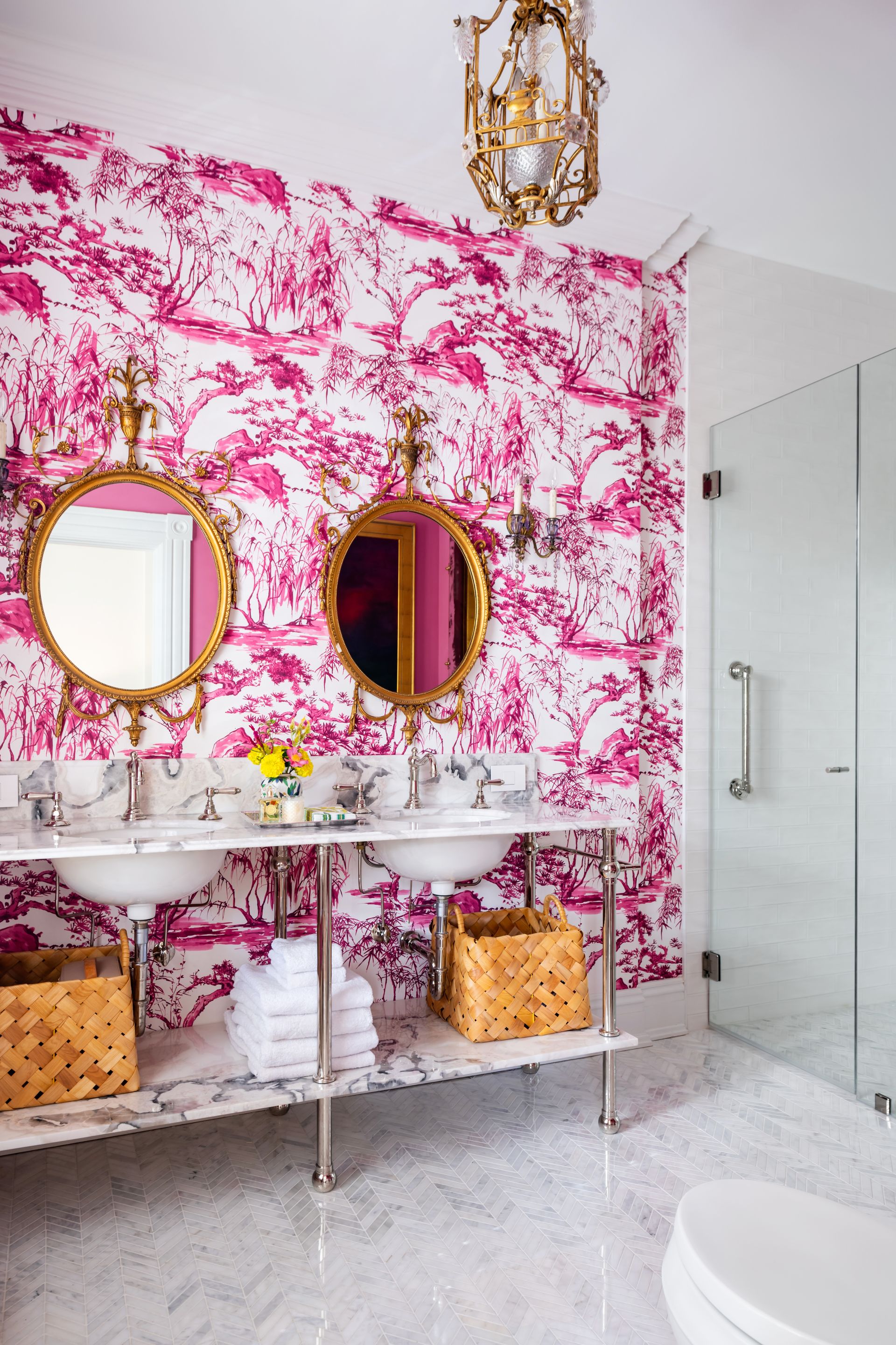 a bathroom with pink and white wallpaper and two sinks
