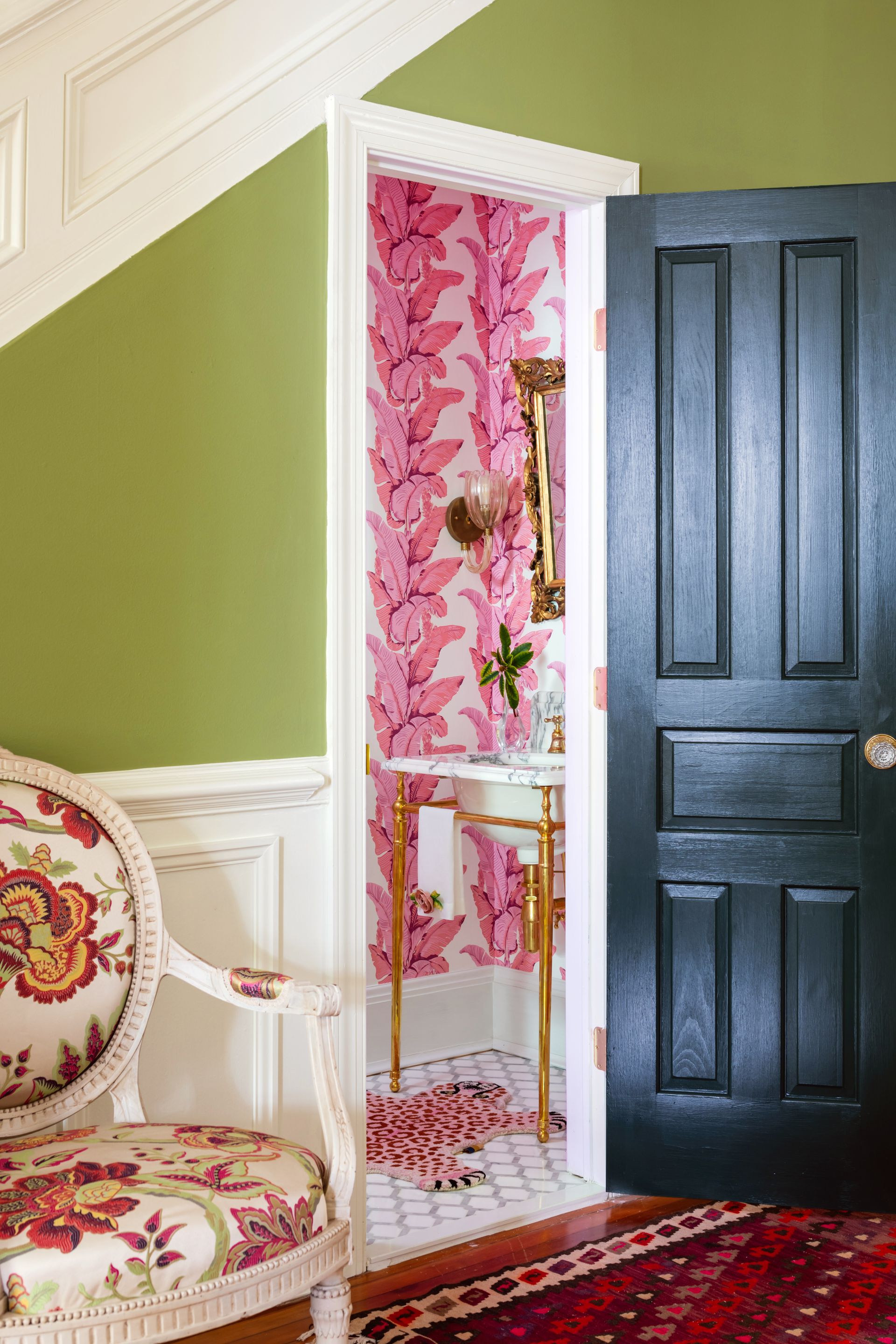 a room with green walls and pink floral wallpaper