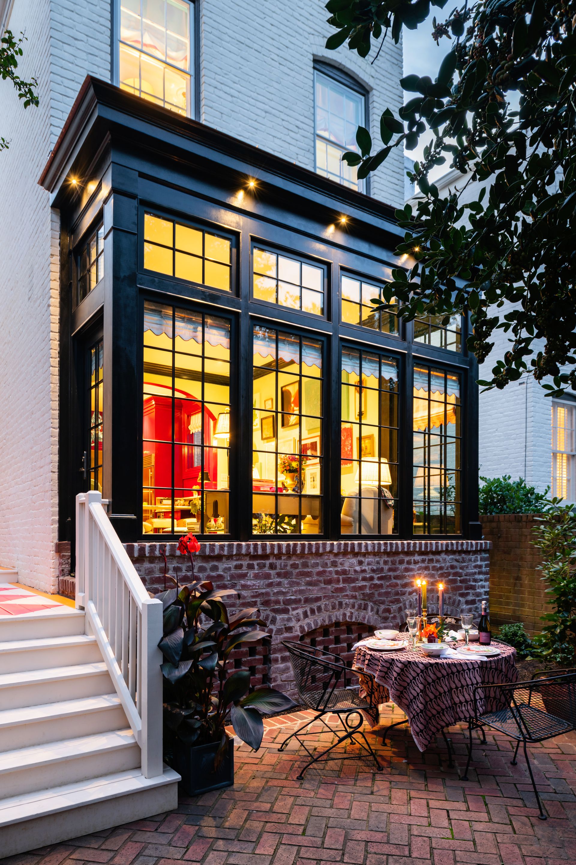 a table and chairs in front of a white house