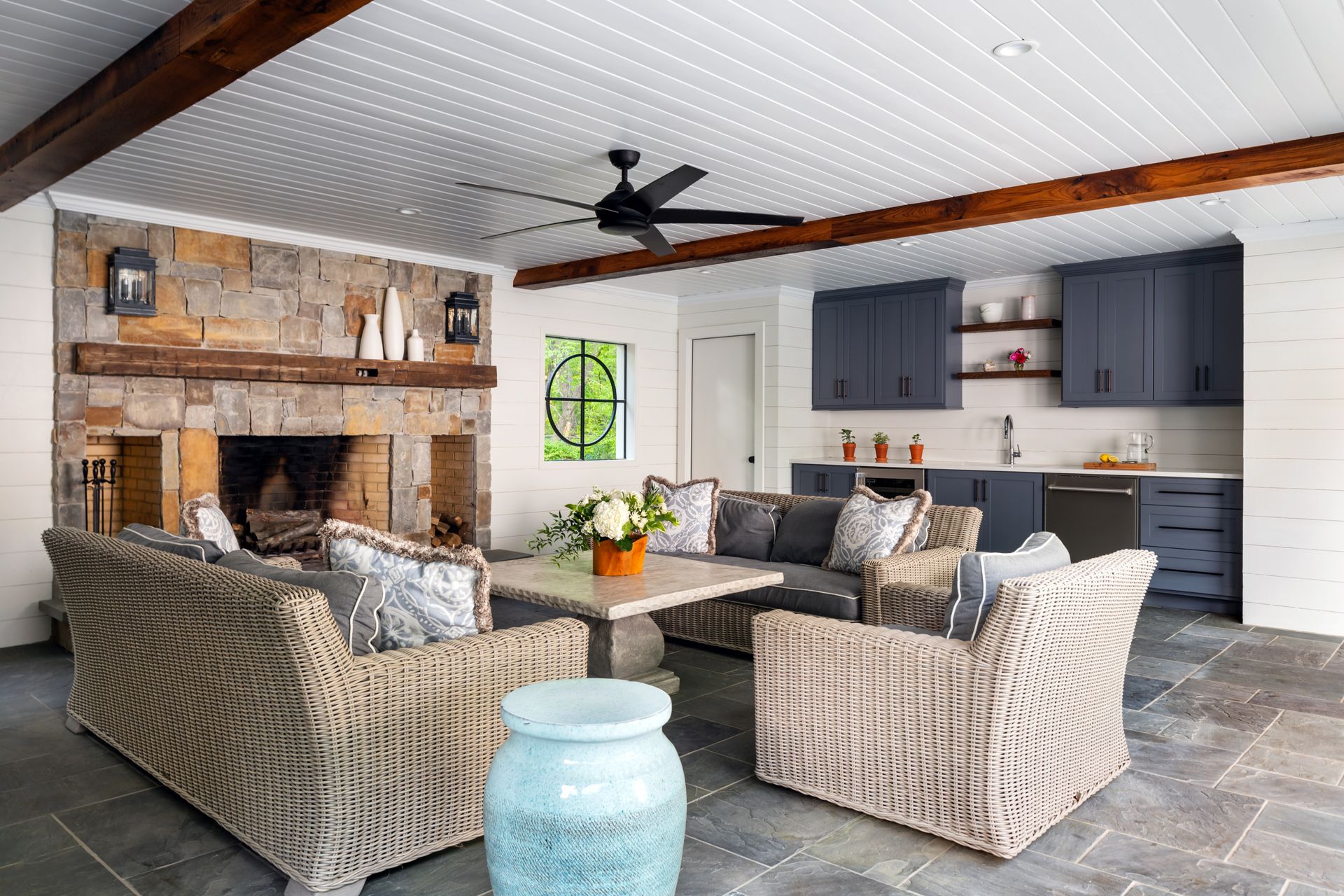 covered outdoor patio with fireplace and kitchenette 