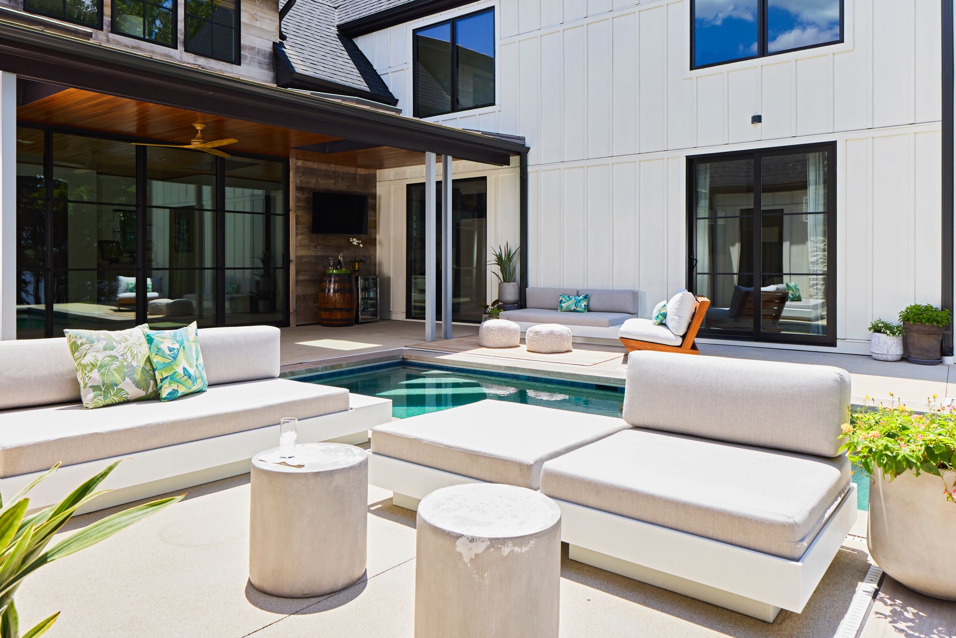 There is a swimming pool in the backyard of a house.