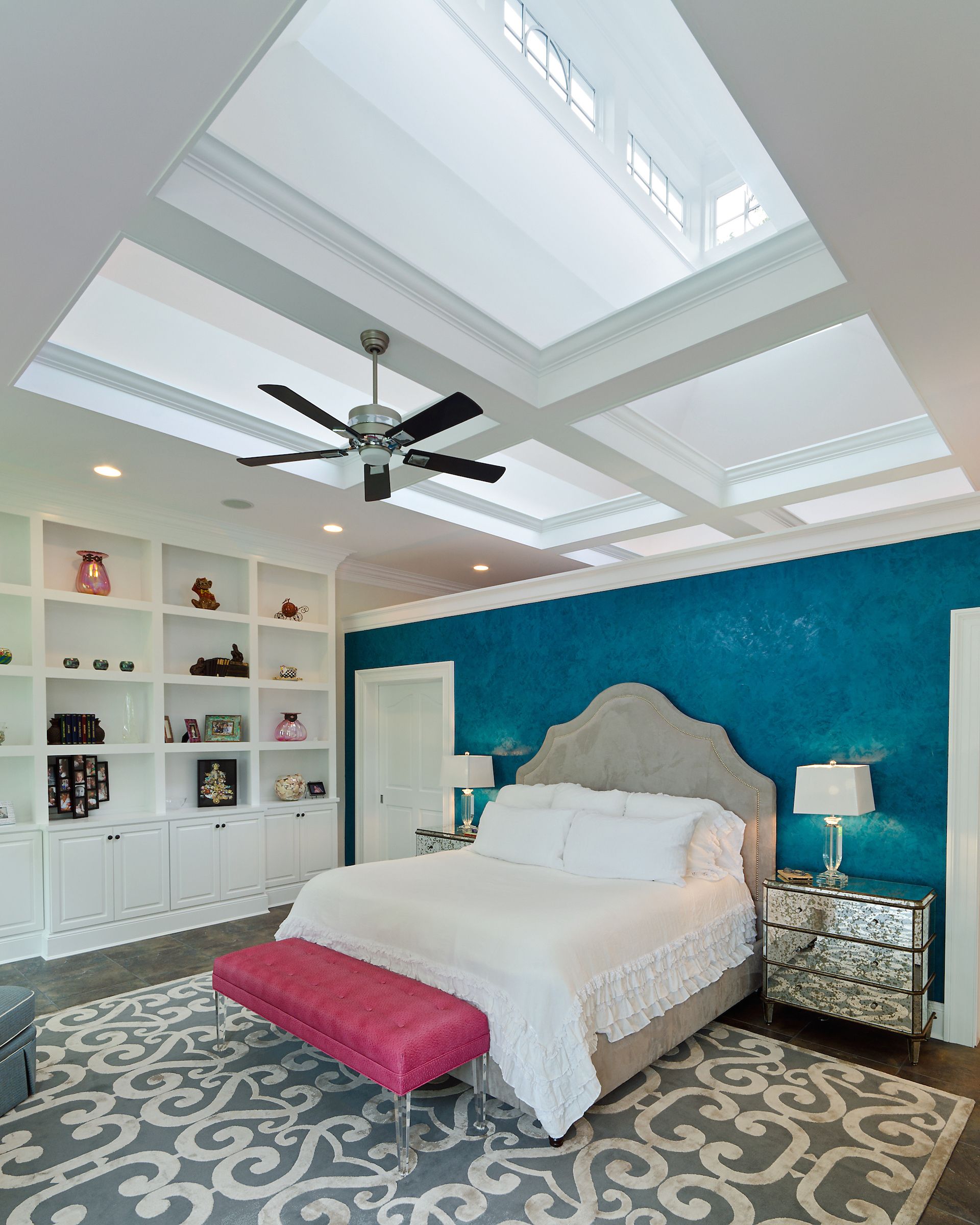 a bedroom with blue walls and a ceiling fan