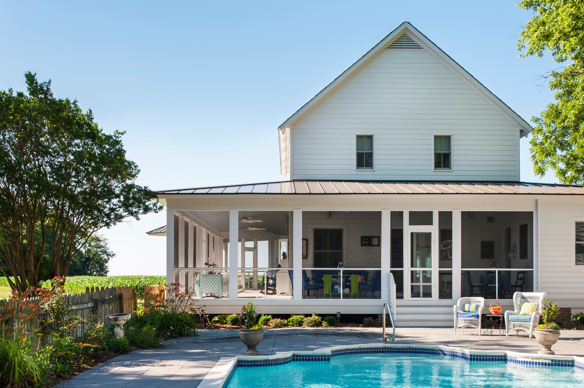 a white house with a screened in porch and a swimming pool