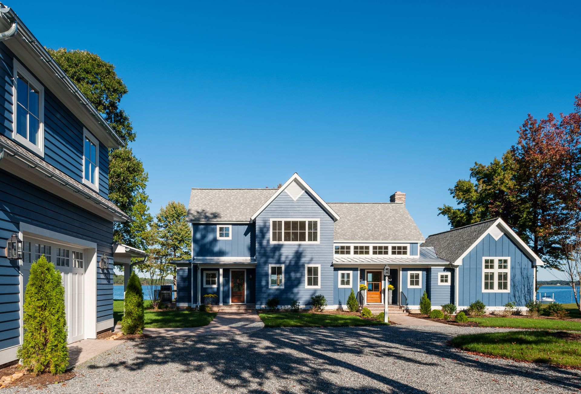 a large blue house with a driveway leading to it