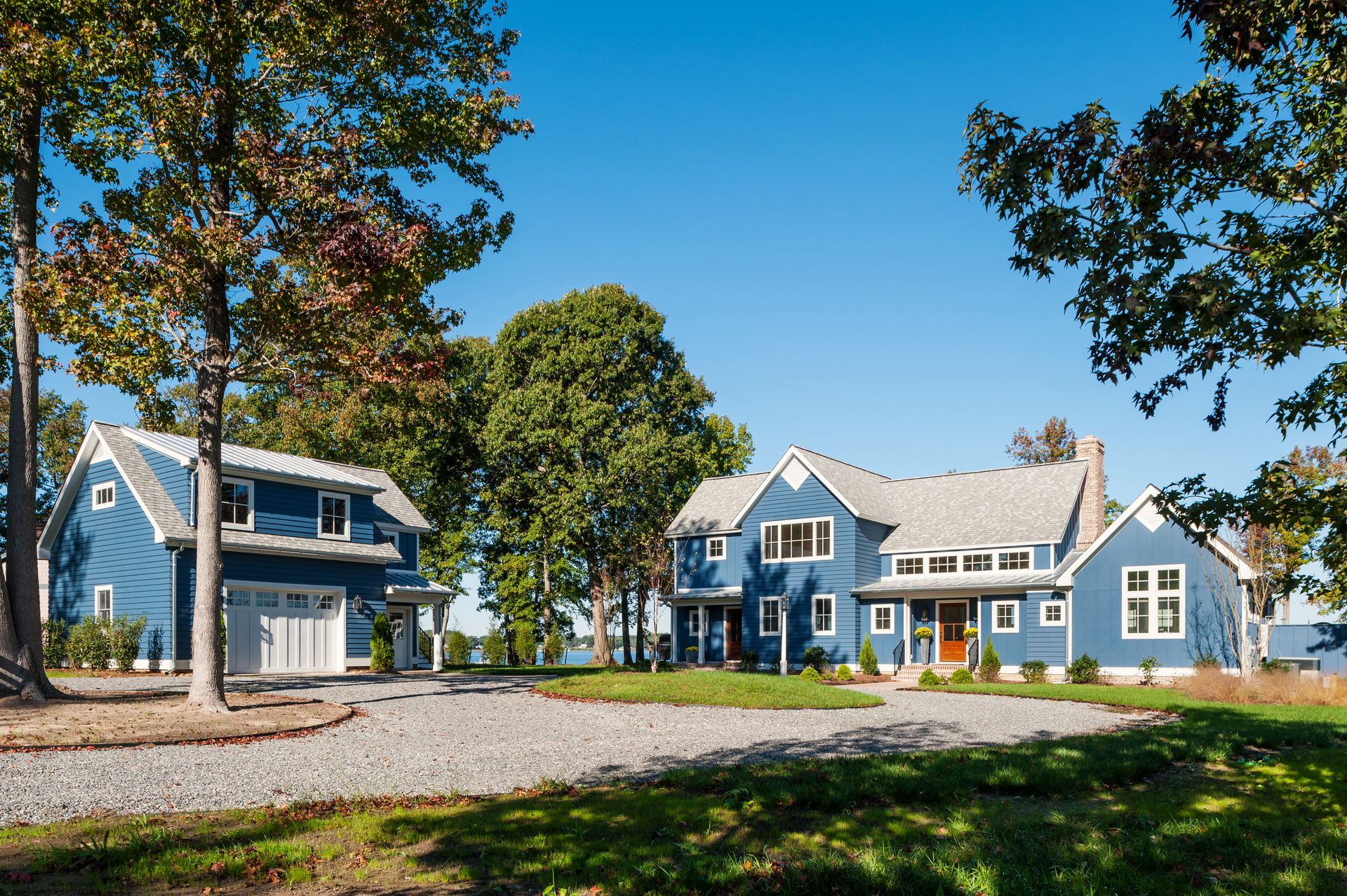 a blue house with a garage and a red door