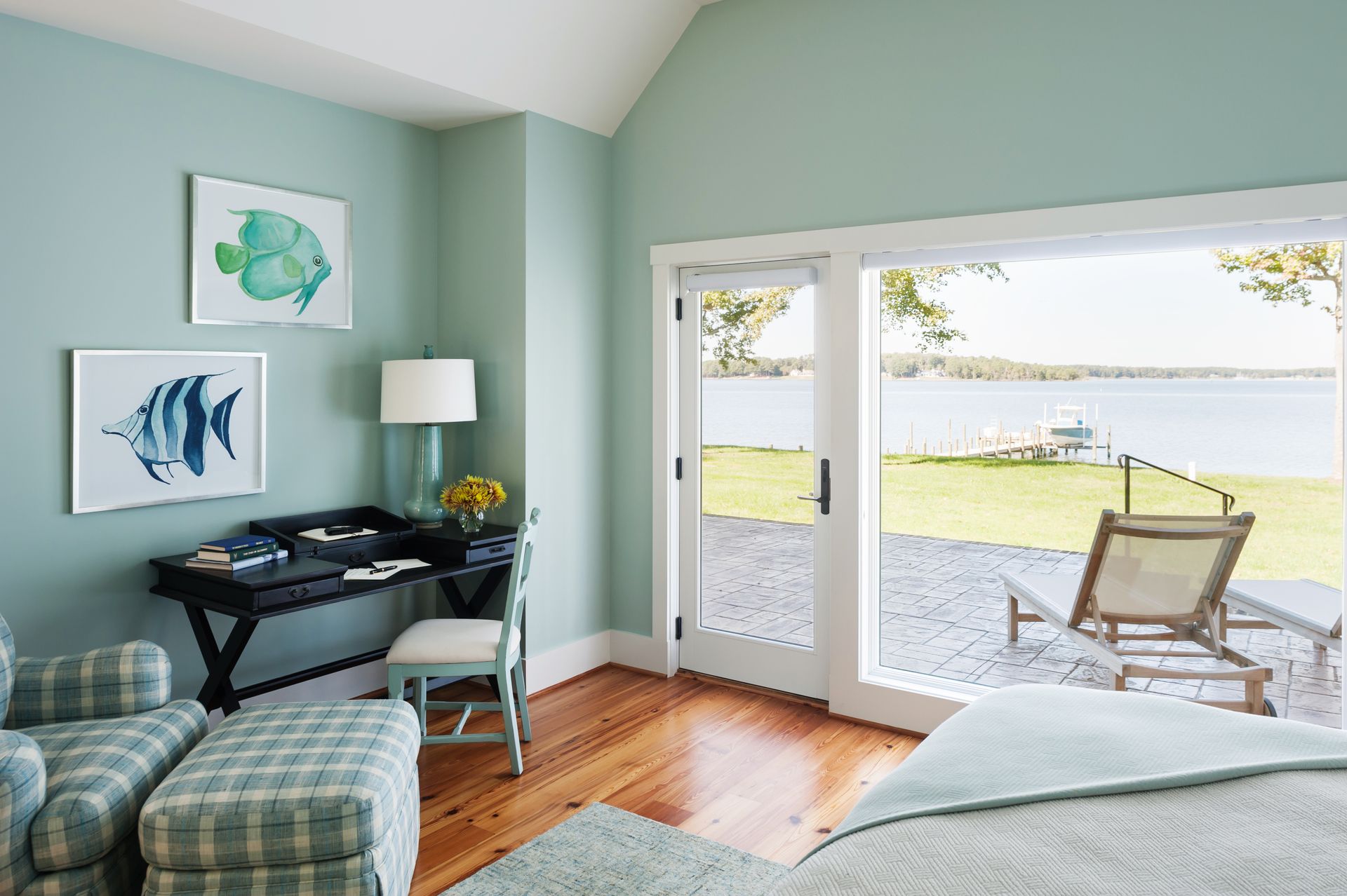 a bedroom with blue walls and a view of a lake