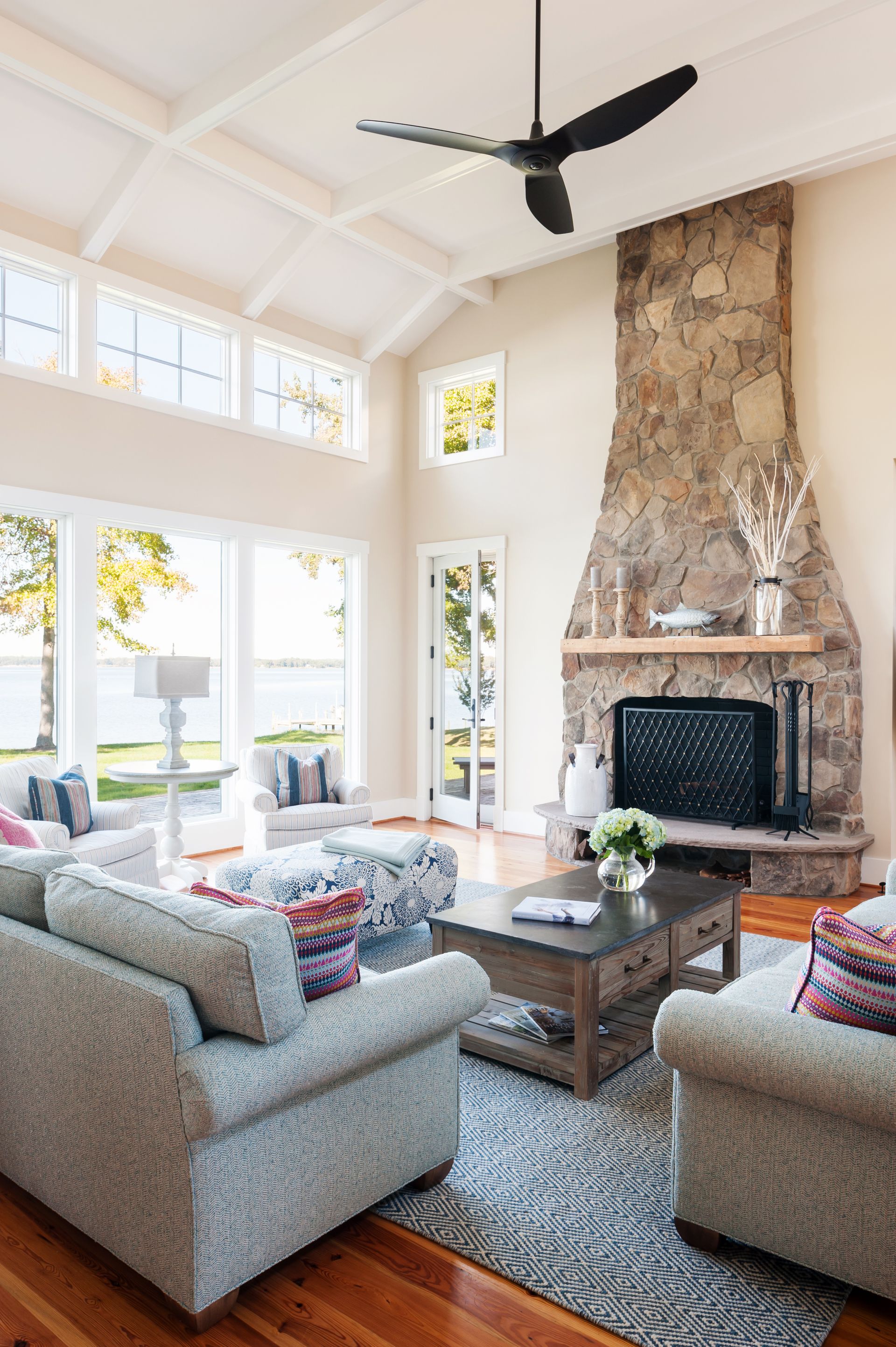 a living room with a fireplace and a ceiling fan