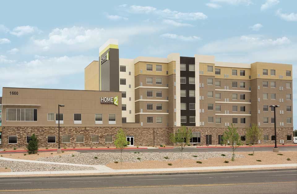 A large building with a lot of windows is next to a road.
