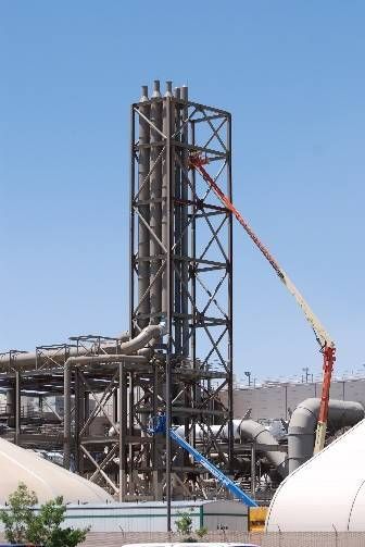 A large industrial plant with a crane in front of it