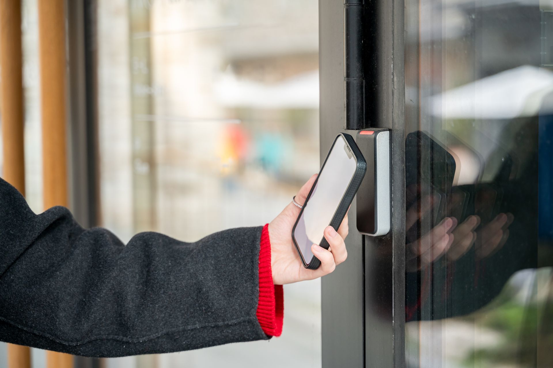 A person is using a smart phone to open a door.
