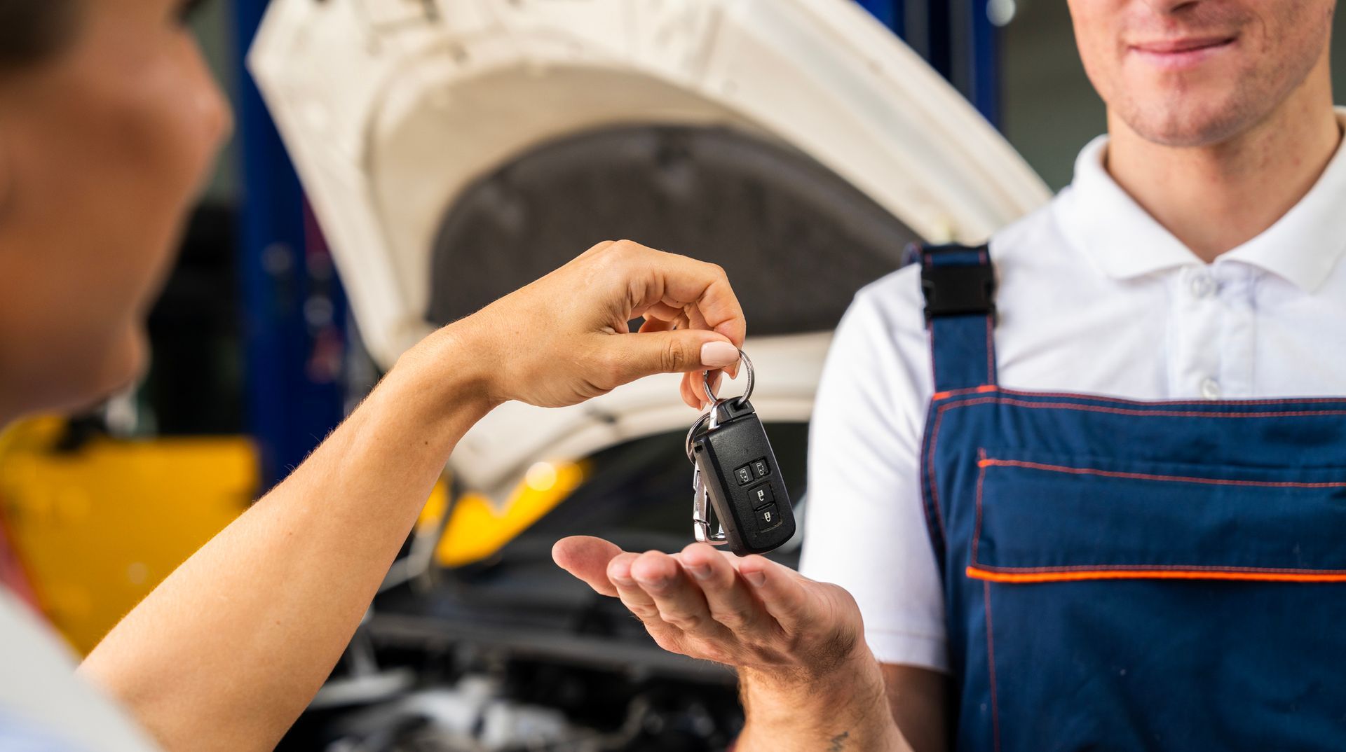 A man is giving a car key to another man.