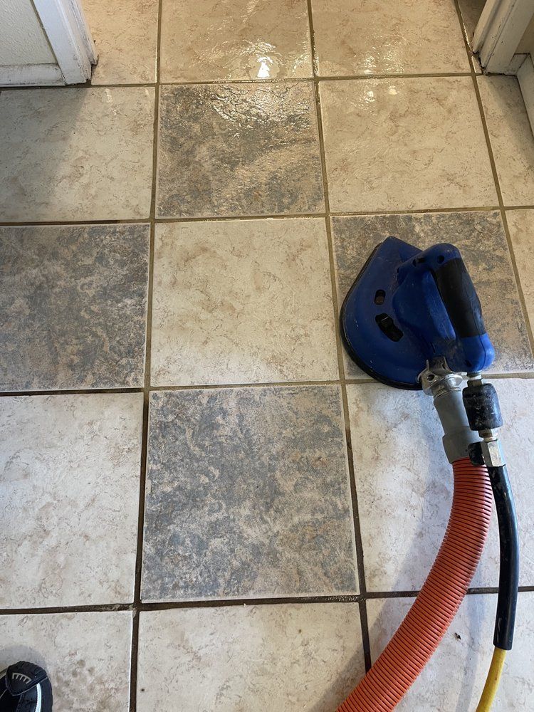 A tile floor with a vacuum cleaner attached to it.