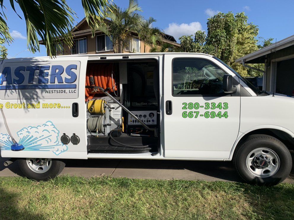 A white asters van is parked in front of a house