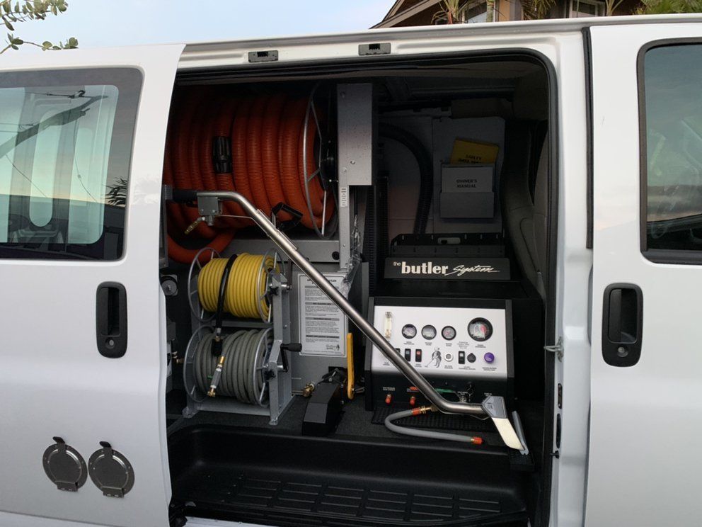 A white van with the door open and a machine in the back