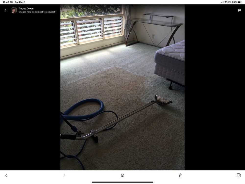A vacuum cleaner is sitting on a carpet in a room.