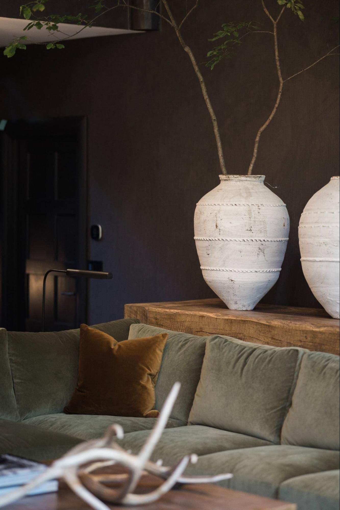A living room with a couch and two vases on a 2500 pound table.