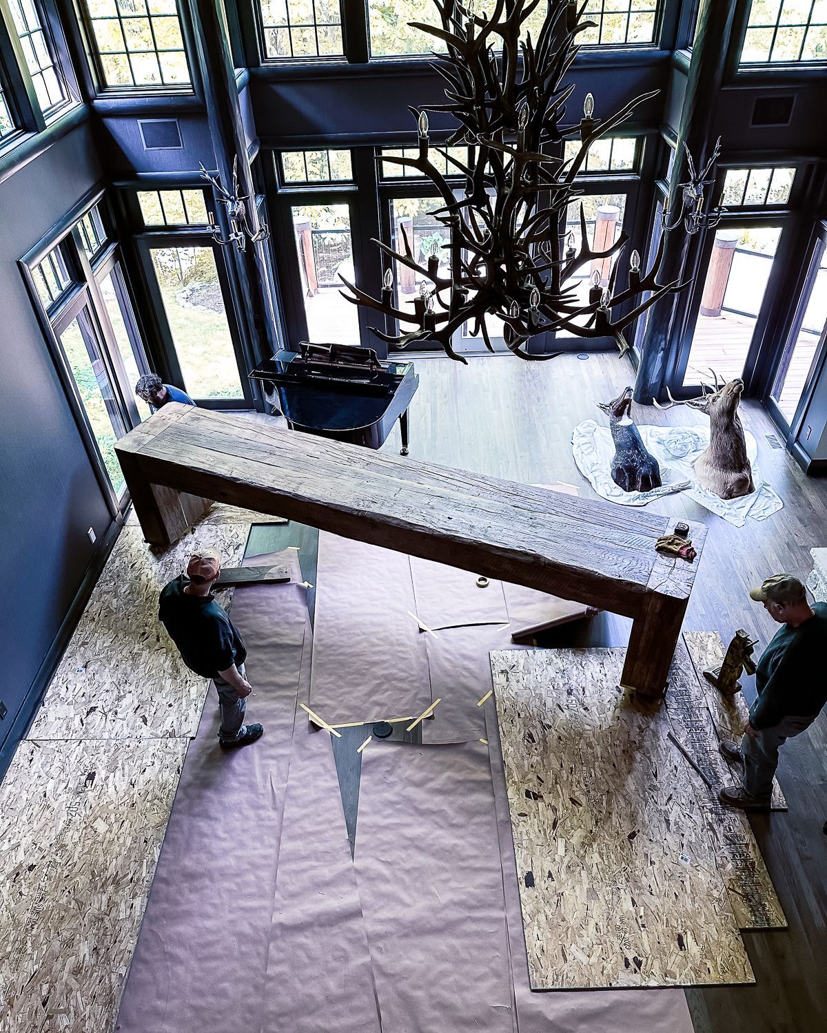 A large wooden table is being moved in a large room.