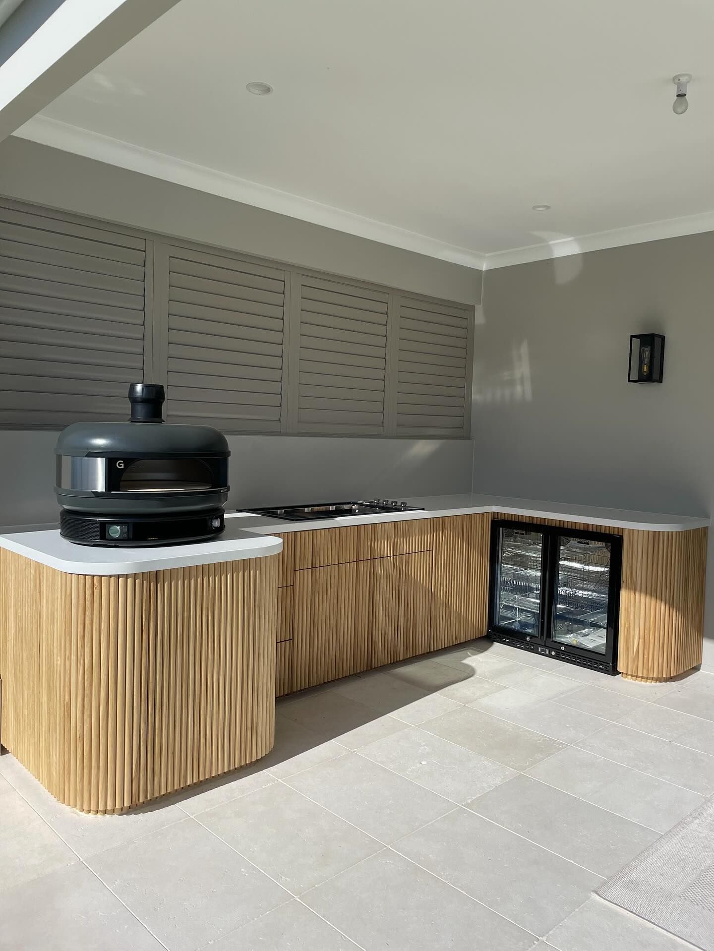 Outdoor Kitchen With Dark Gray Bar, Stools, And Couch — Protech Renovations & Joinery in Gregory Hills, NSW