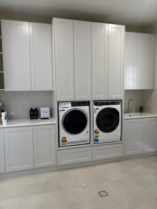 Laundry room with stacked white washer/dryer, sink, and white cabinets. — Protech Renovations & Joinery in Gregory Hills, NSW