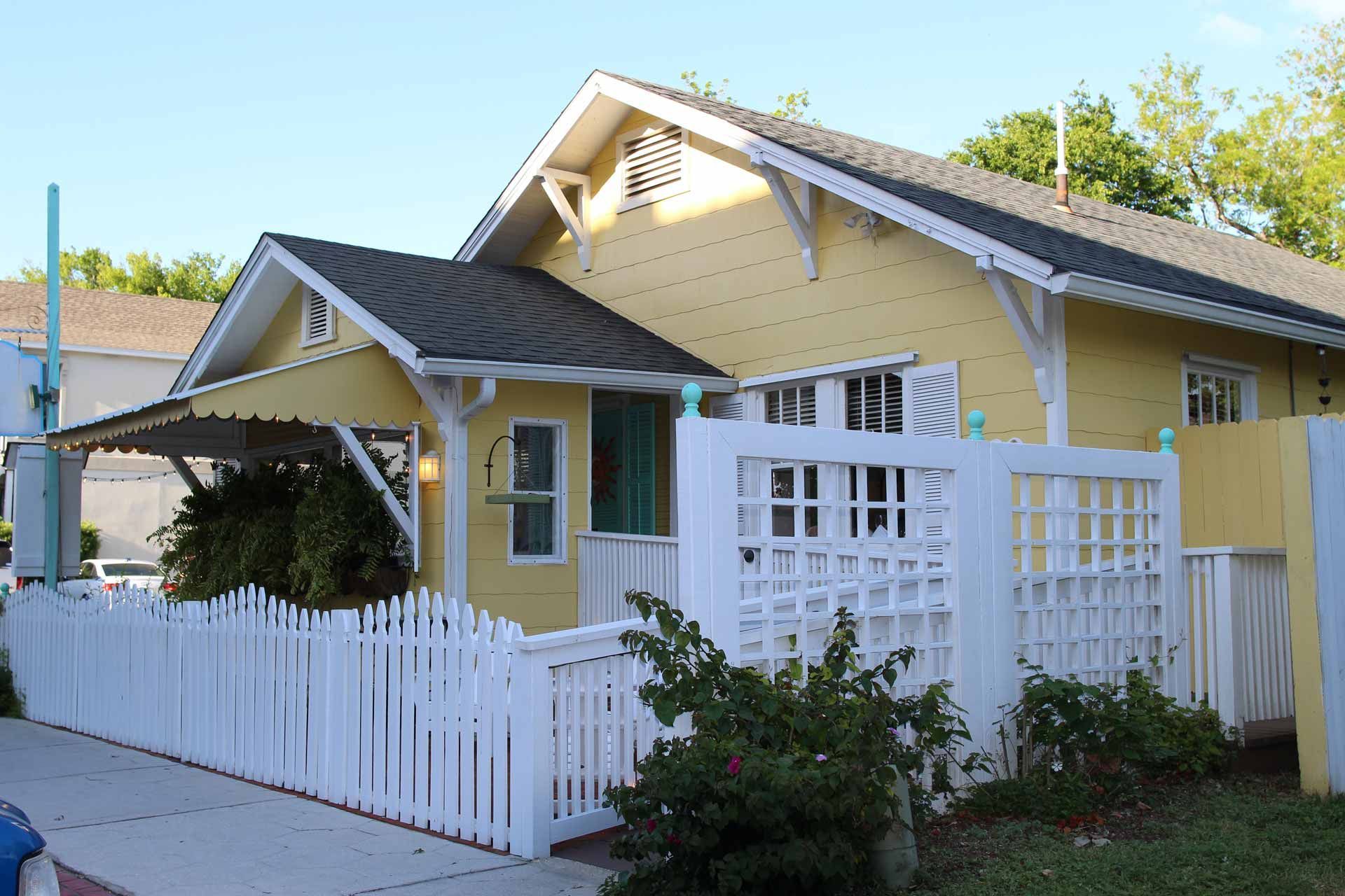 Residential neighborhood with curved road, tan houses, green lawns and solar panels.