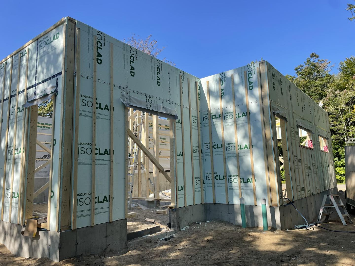 Extérieur d'un bâtiment en construction, ossature bois avec panneaux isolants.