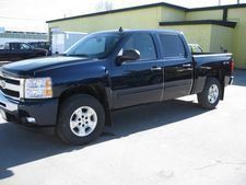 Black pickup truck parked outside a building on a sunny lot