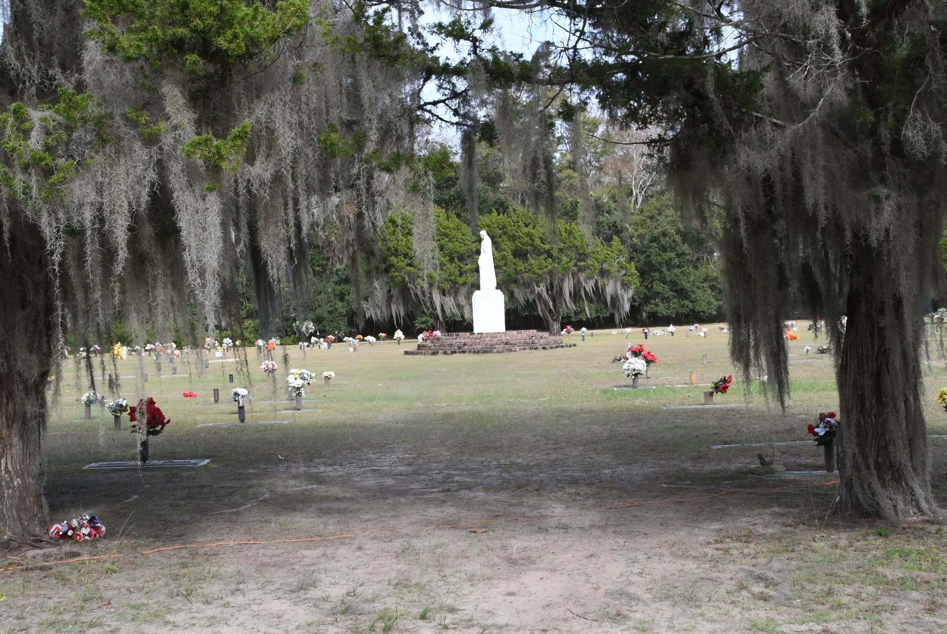 A cemetery with a statue in the middle of it