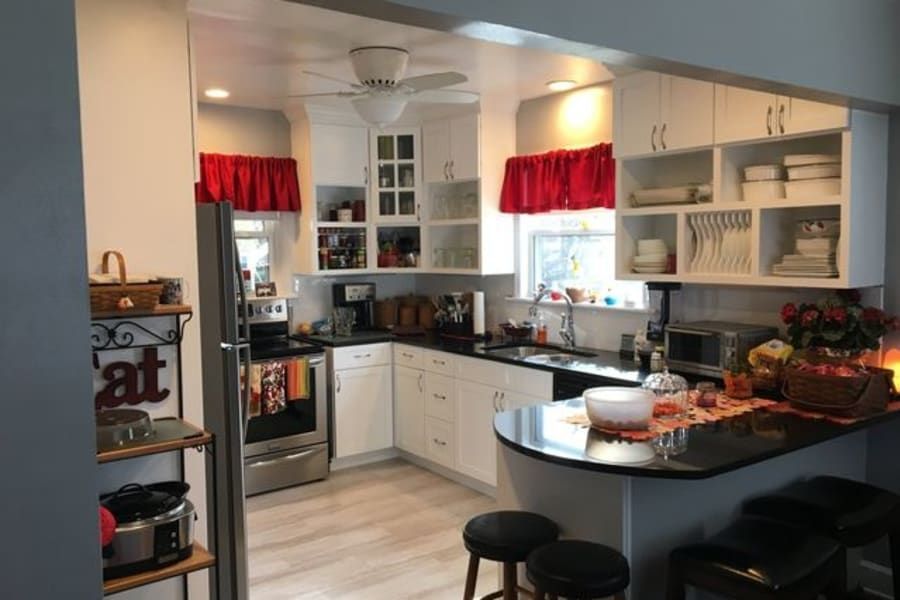 A kitchen with white cabinets and black counter tops