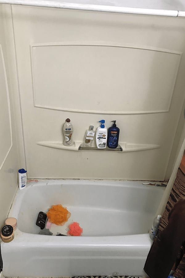 A bathtub filled with soap and sponges in a bathroom.