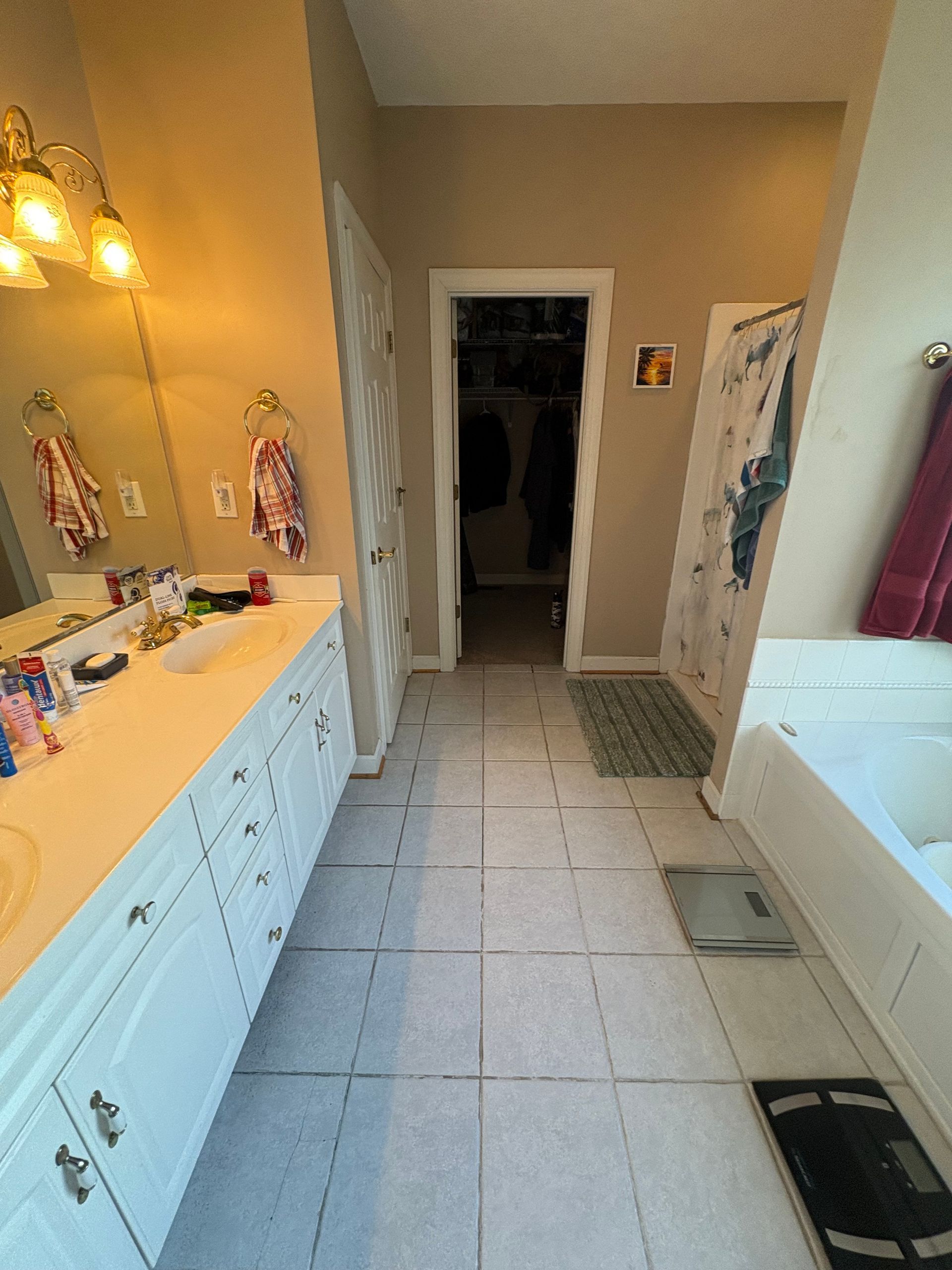 Modern bathroom vanity area with black cabinets, large mirrors, and patterned accent wall.