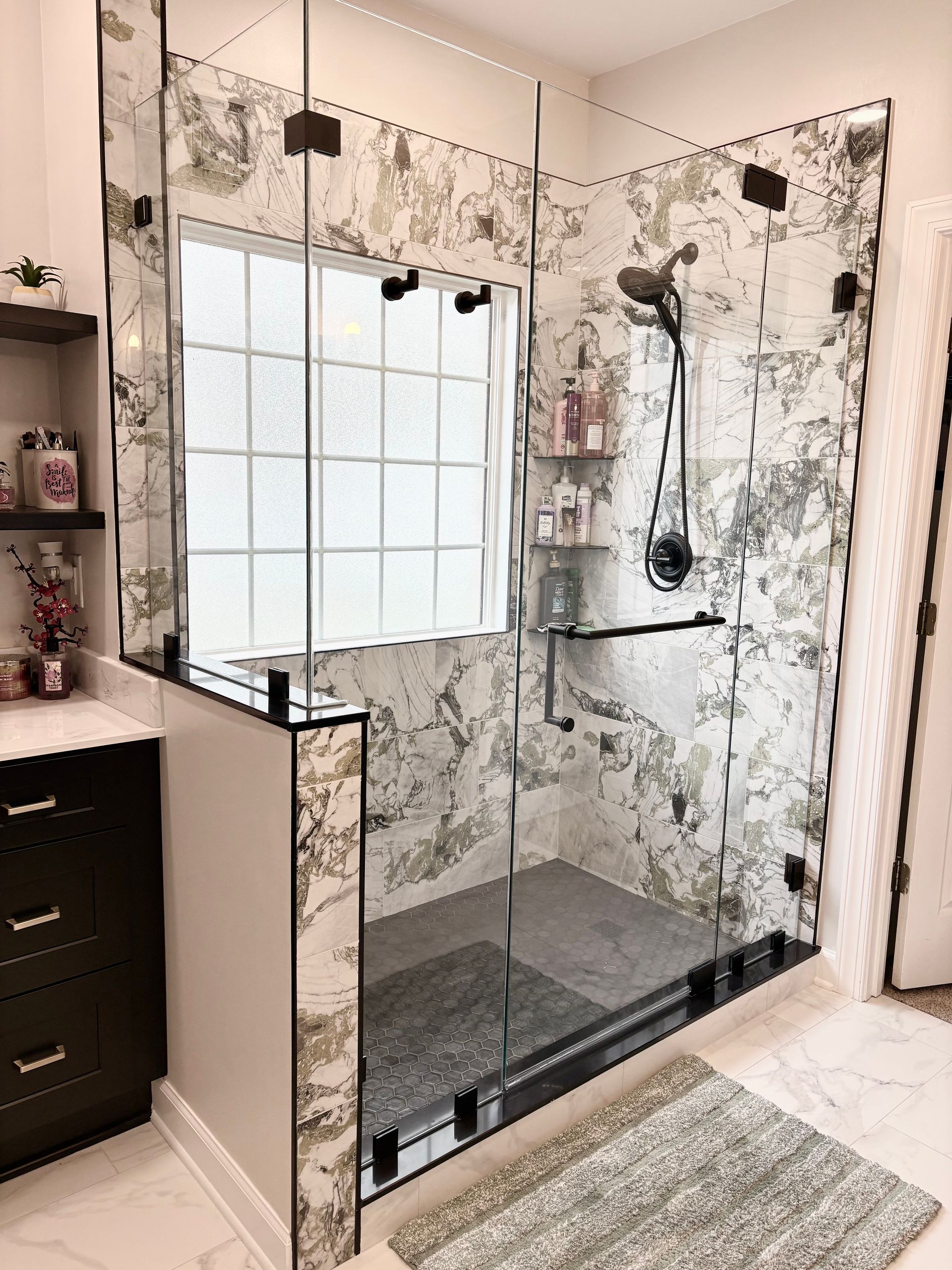 Modern tiled walk-in shower with glass enclosure and rainfall showerhead in a bright bathroom