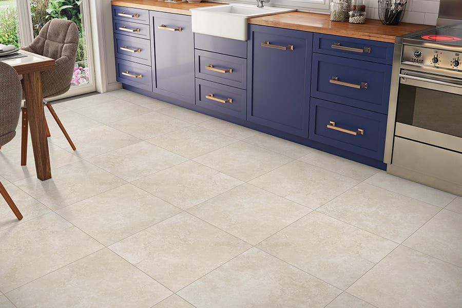 A kitchen with blue cabinets and a white tile floor.