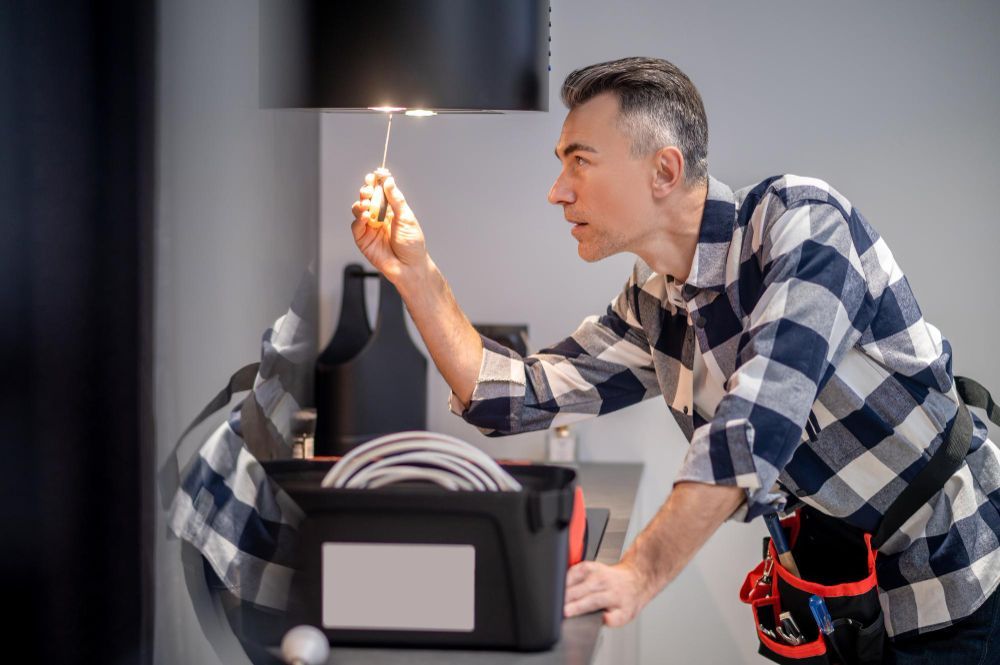 Technician inspecting a washing machine with a lighter in a laundry room