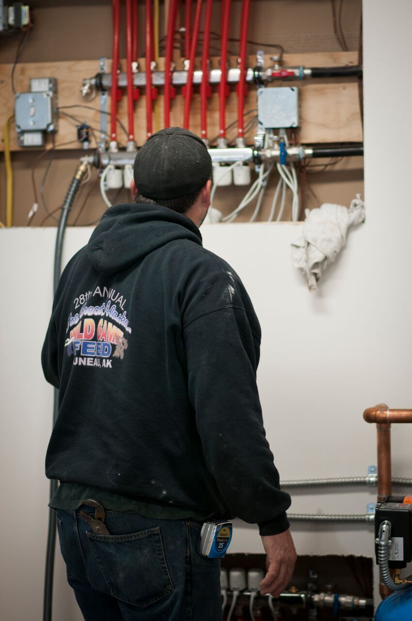 Man Inspecting Floor Heating — Juneau, AK — Icy Strait Plumbing & Heating