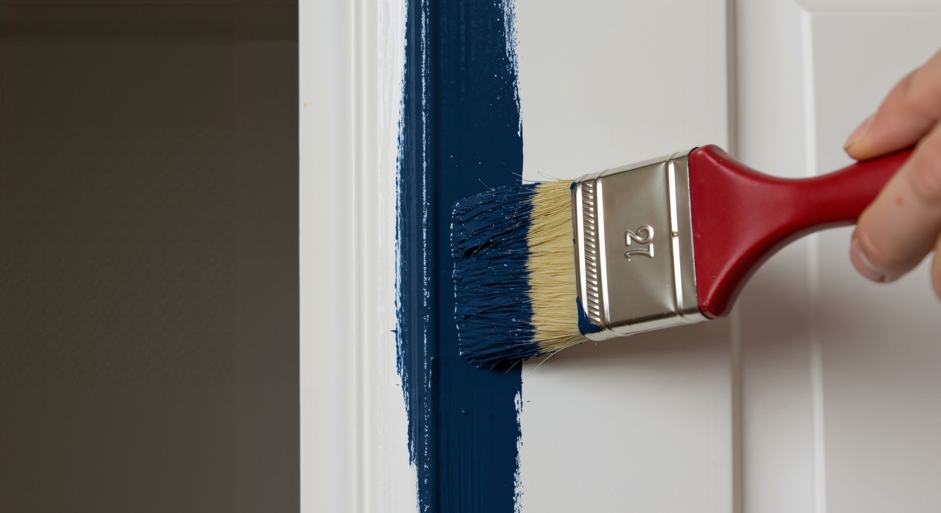 A person is painting a door with a blue brush.