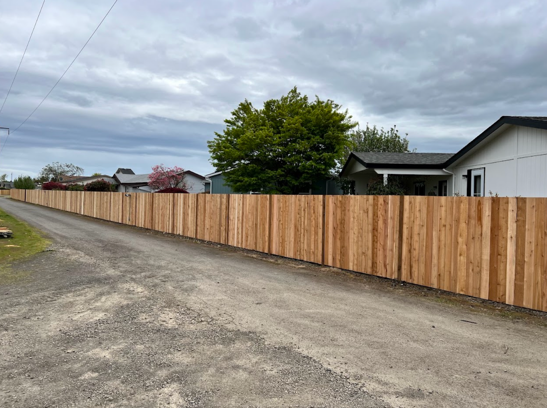 Two men are working on a wooden fence.