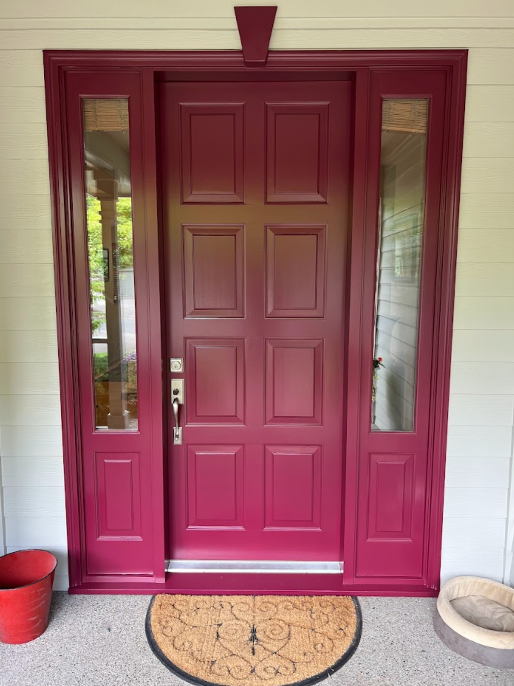 A person is painting a door with a blue brush.