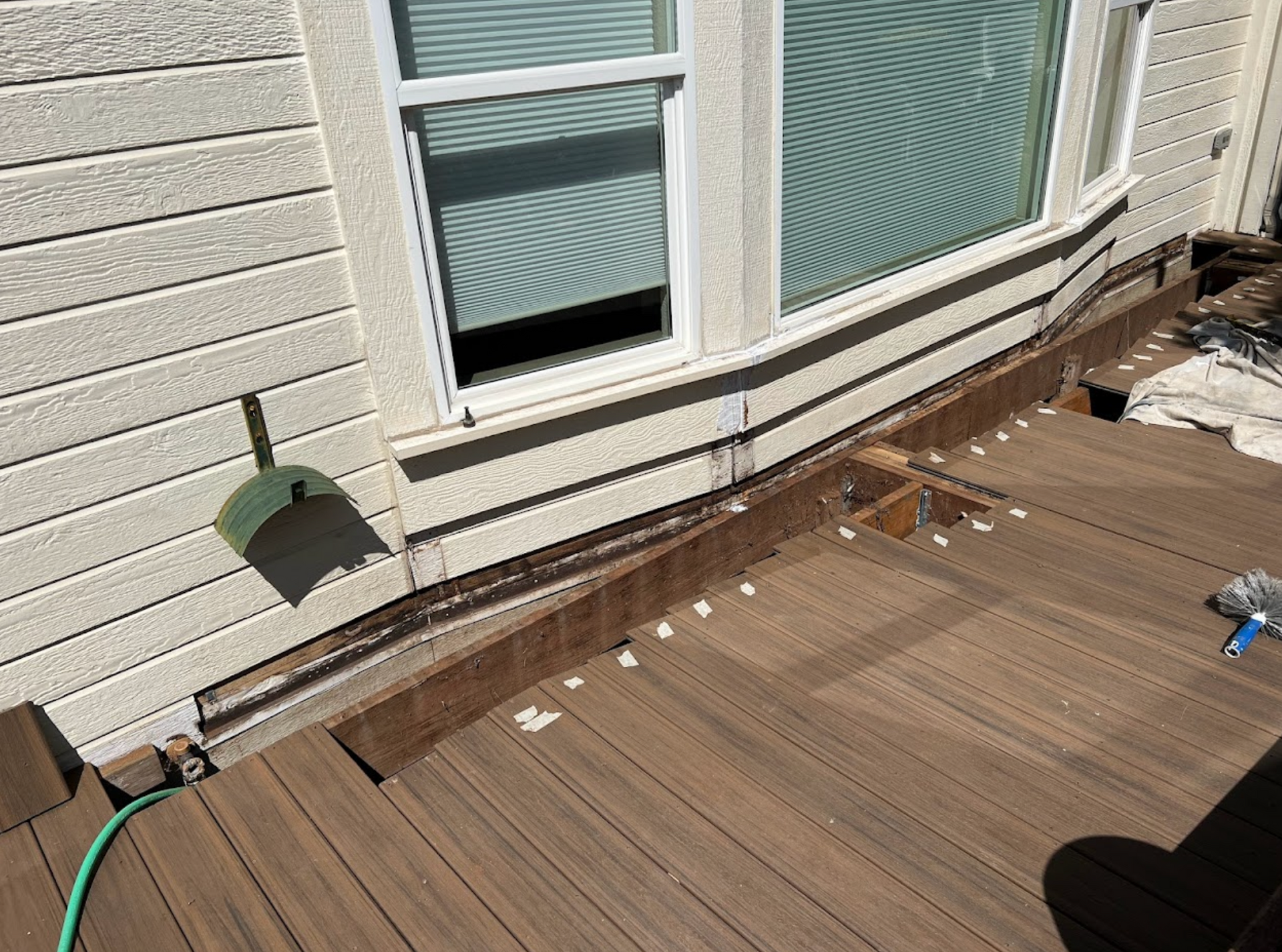 A person wearing orange gloves is installing a wooden floor.