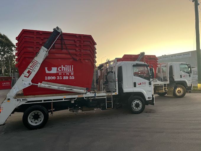 Two Red Dumpsters with Chili Written on Them Are Stacked on Top of Each Other — Chilli Bins Skip Bins in Glenview, QLD