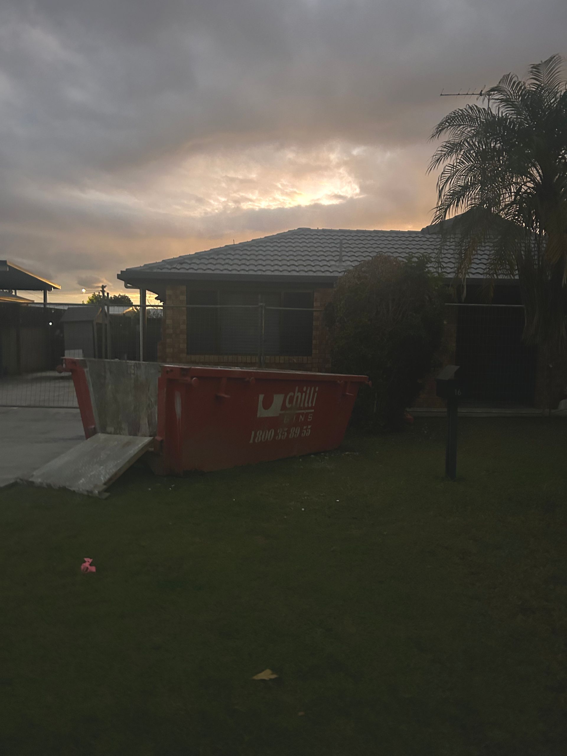 A White Car Is Parked in Front of A House — Chilli Bins Skip Bins in Redcliffe, QLD