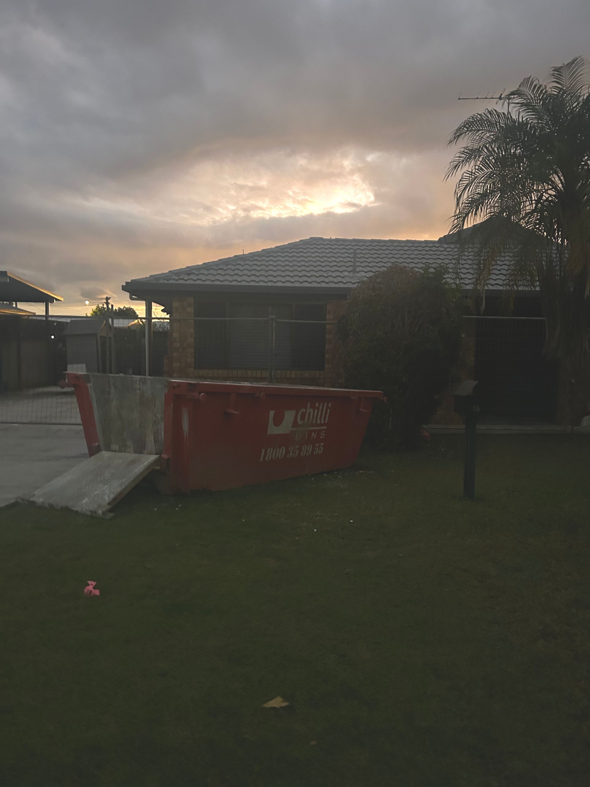 A White Car Is Parked in Front of A House — Chilli Bins Skip Bins in Glenview, QLD