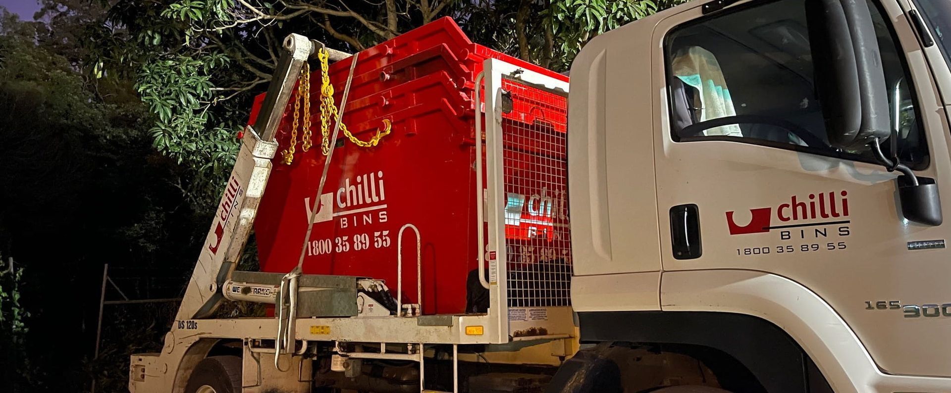 Red and White Chilli Waste Disposal Truck Parked at Night, With Logo on the Side