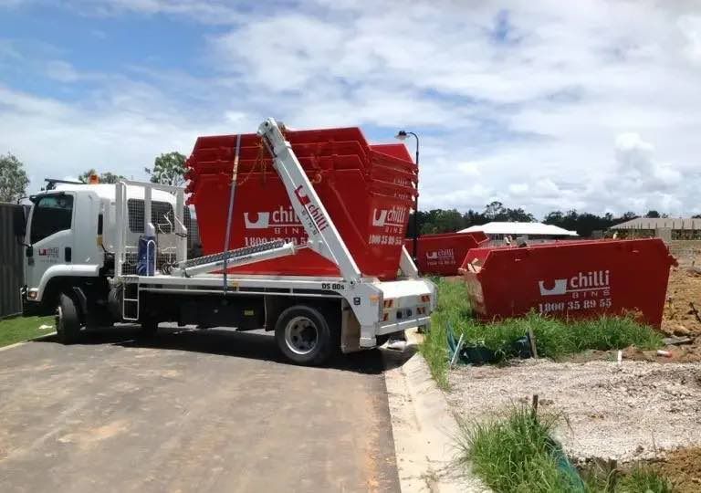 A Dumpster Truck Is Parked on The Side of The Road — Chilli Bins Skip Bins in Glenview, QLD