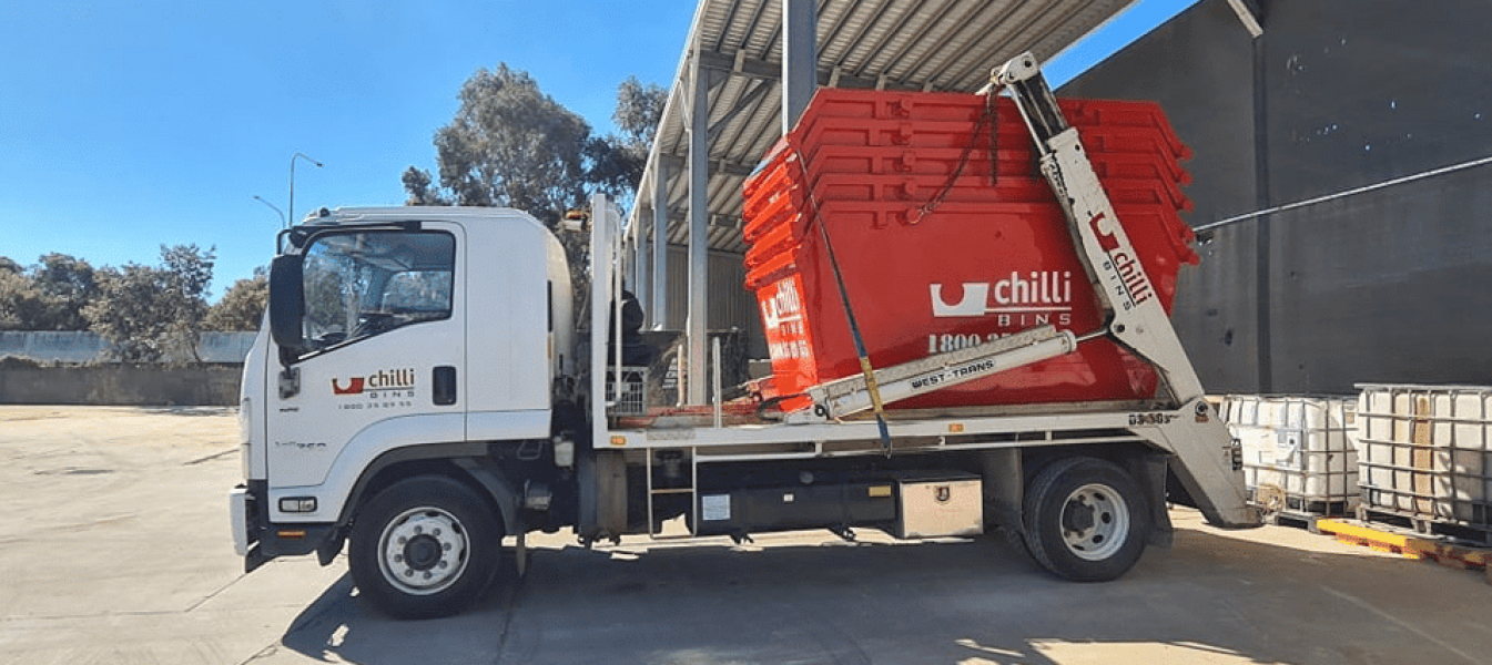 A Dump Truck Is Parked in A Parking Lot Next to A Building — Chilli Bins Skip Bins in Glenview, QLD