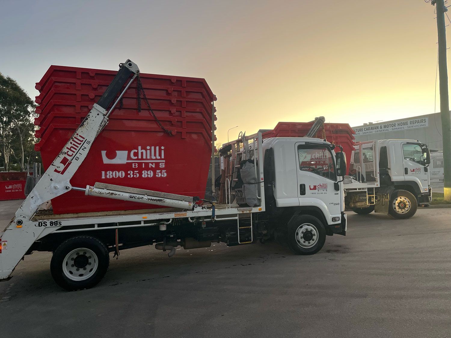 Red Skip Bins Loaded On A Trailer